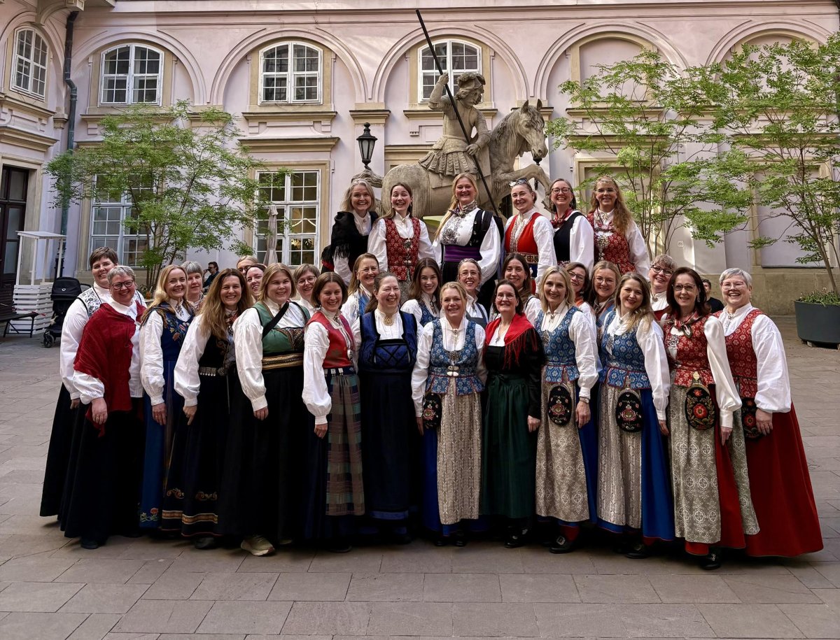 Koret Hedda kledd i bunad foran en statue i Bratislava